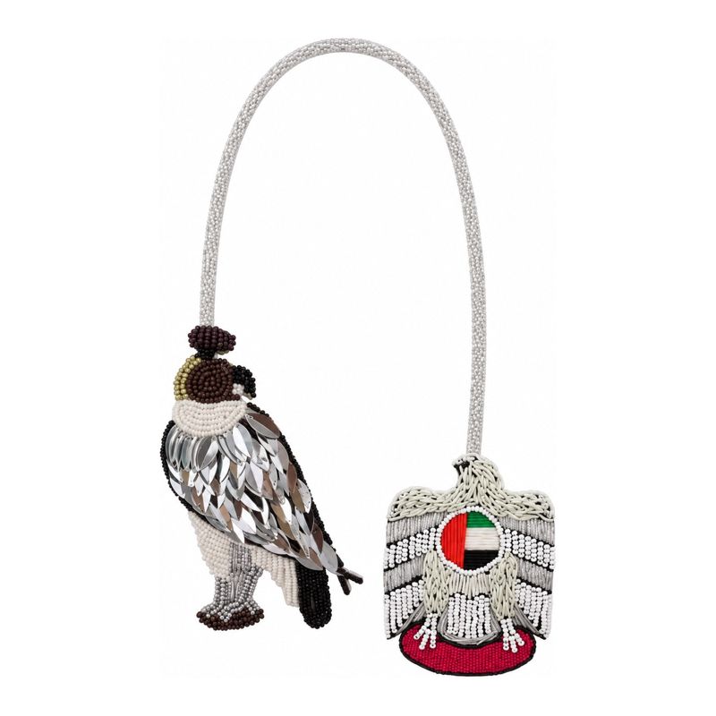 Necklace with a beaded falcon charm and a silver UAE emblem charm